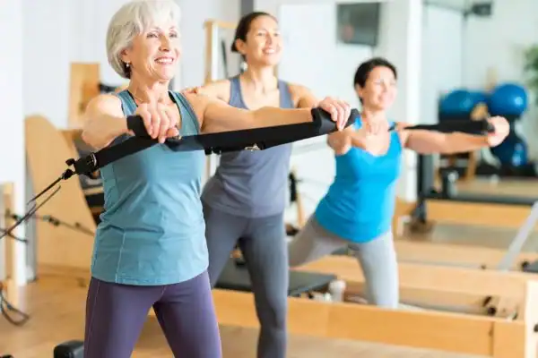 Toning Arms After 60: Empowering Womens Fitness Through Effective Weight Training 2 older woman doing weight training Billingshurst and resistance in the gym to tone upper arms