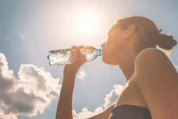 Hydration: The Secret Ingredient for a Toned Stomach and Enhanced Fitness 3 Image of woman drinking water to hydrate Billingshurst after run.